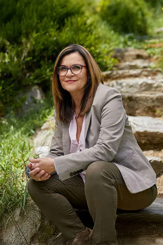 Doris Mock sitzt auf einer Treppe im Garten.